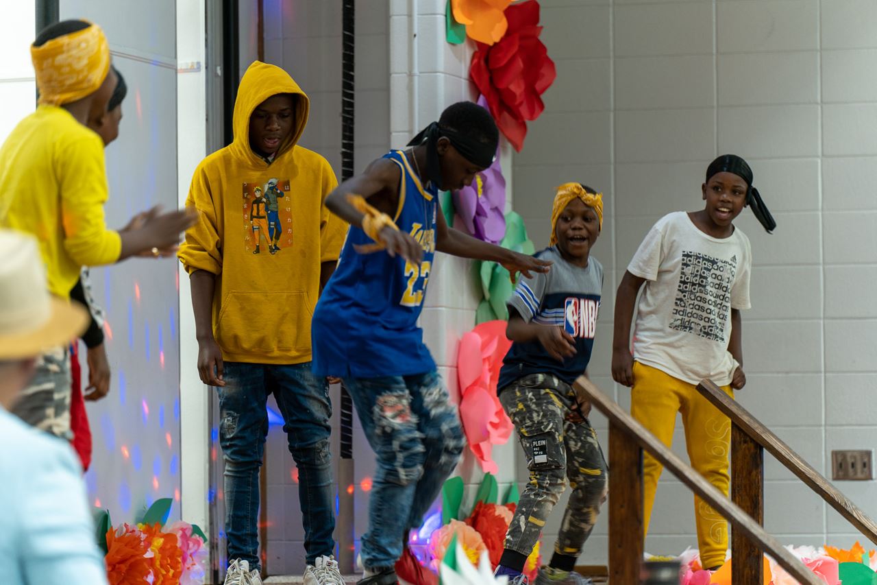 Students dancing and smiling during a school performance event.
