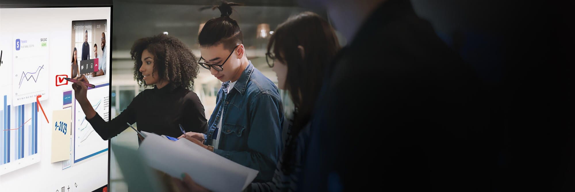 Team of diverse professionals collaboratively using a SMART interactive display to review and discuss digital data and video conferencing.