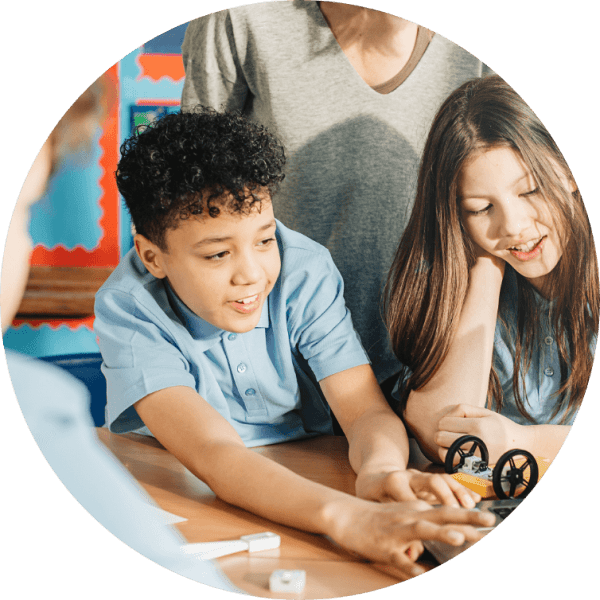 Two students actively engaging with hands-on educational tools in a classroom setting, reflecting collaborative learning.